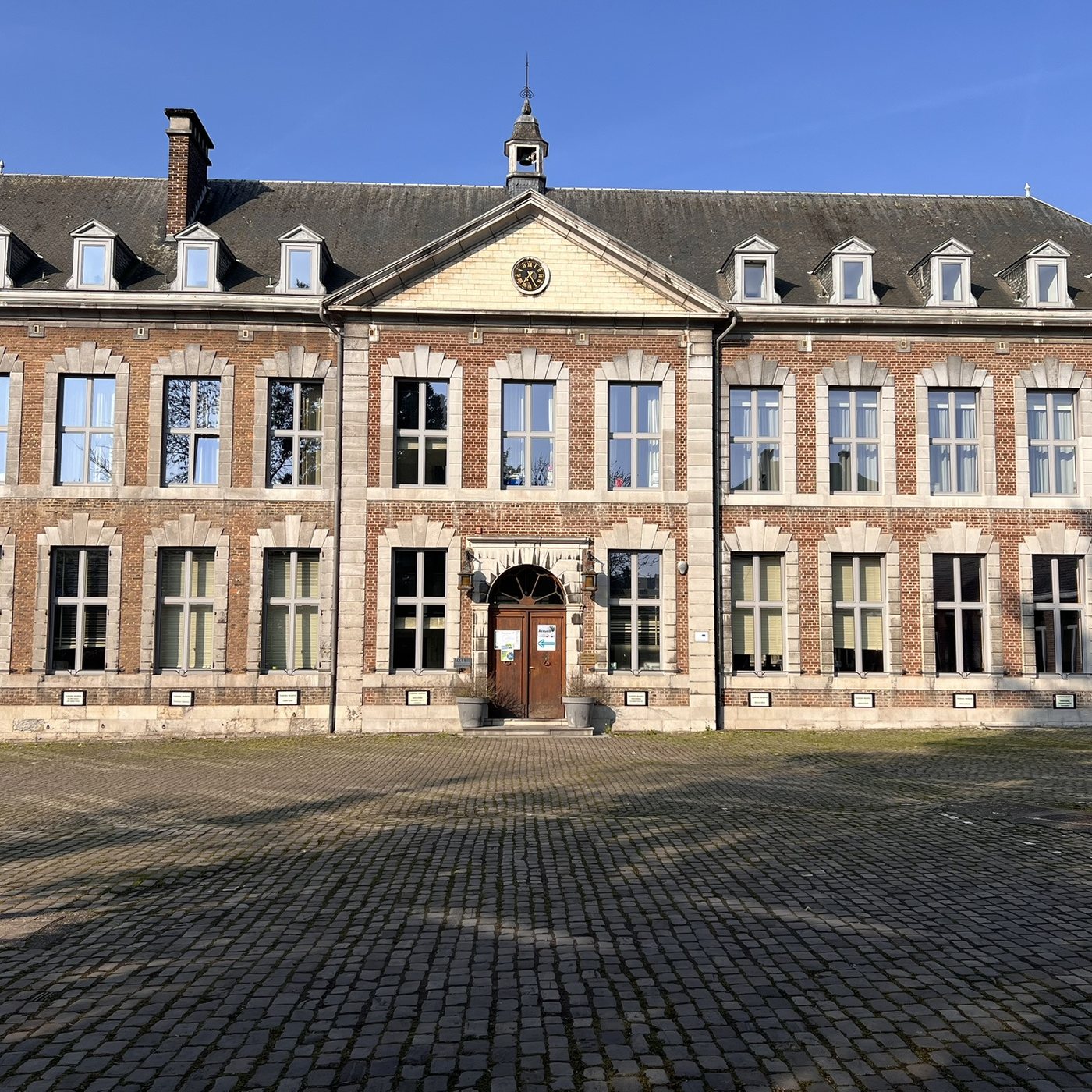 La façade du bâtiment principal de l’implantation de Huy, avec son horloge et son clocheton