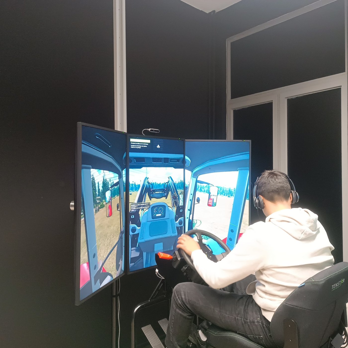 Élève conduisant le simulateur de tracteur, vue cabine