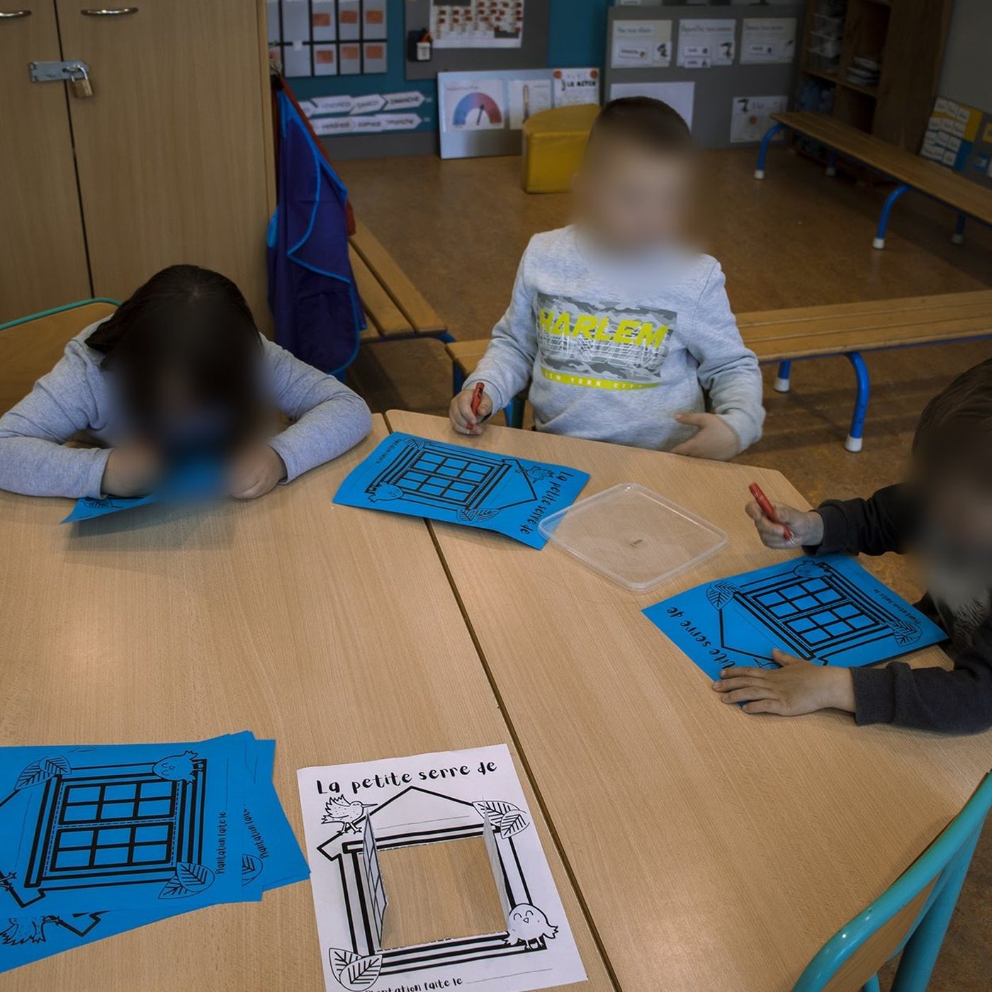 Enfants de maternelle coloriant une fiche