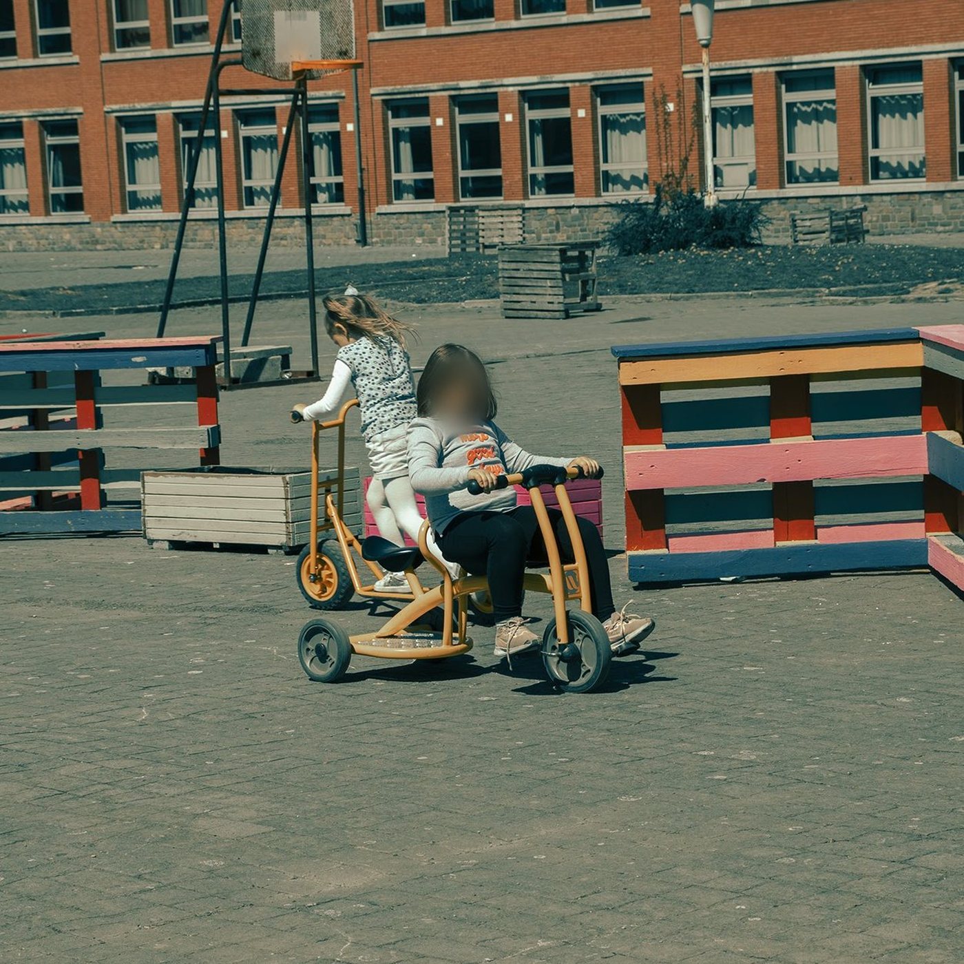 Fillettes sur un tricycle dans la cour