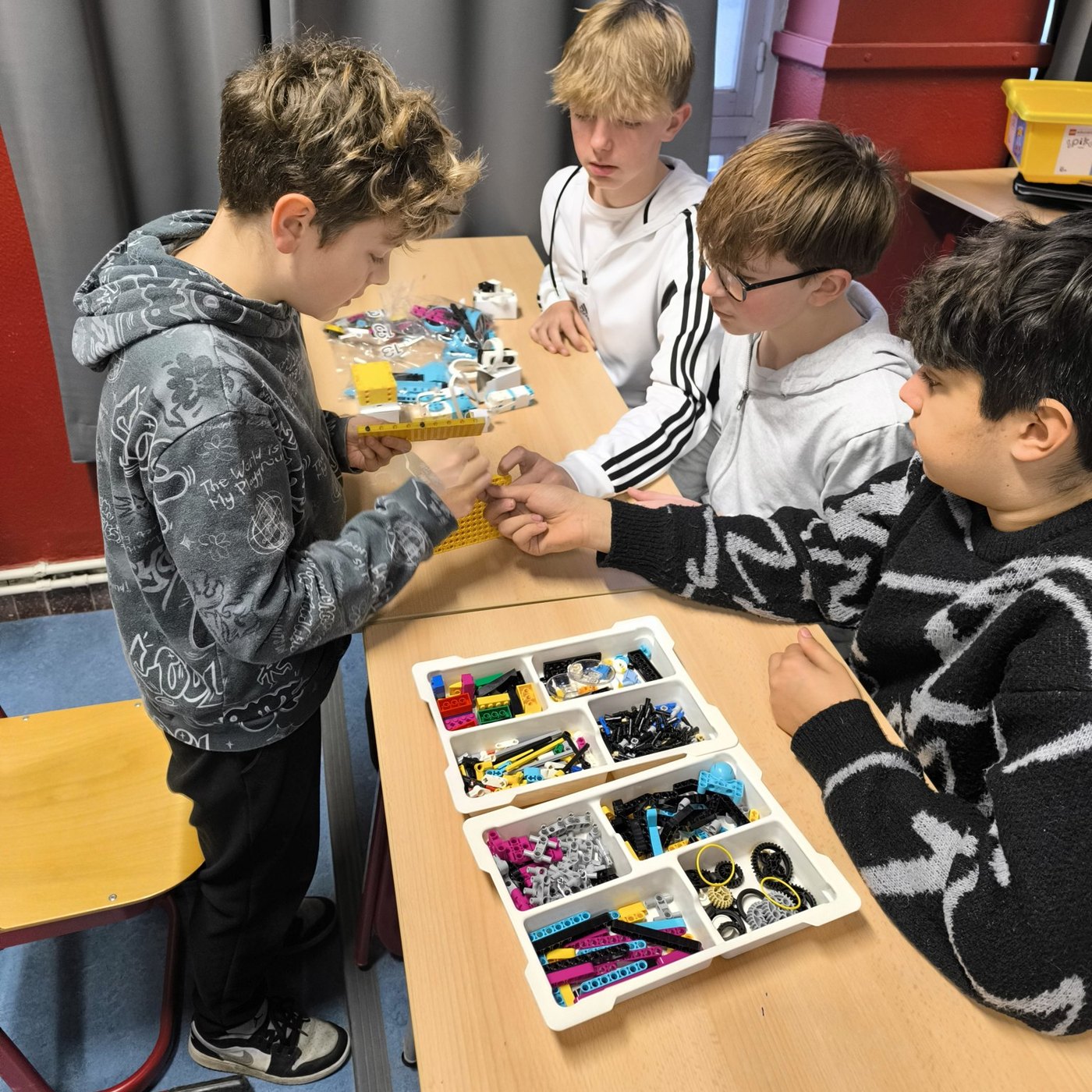 Élèves assemblant un robot au cours de technologie