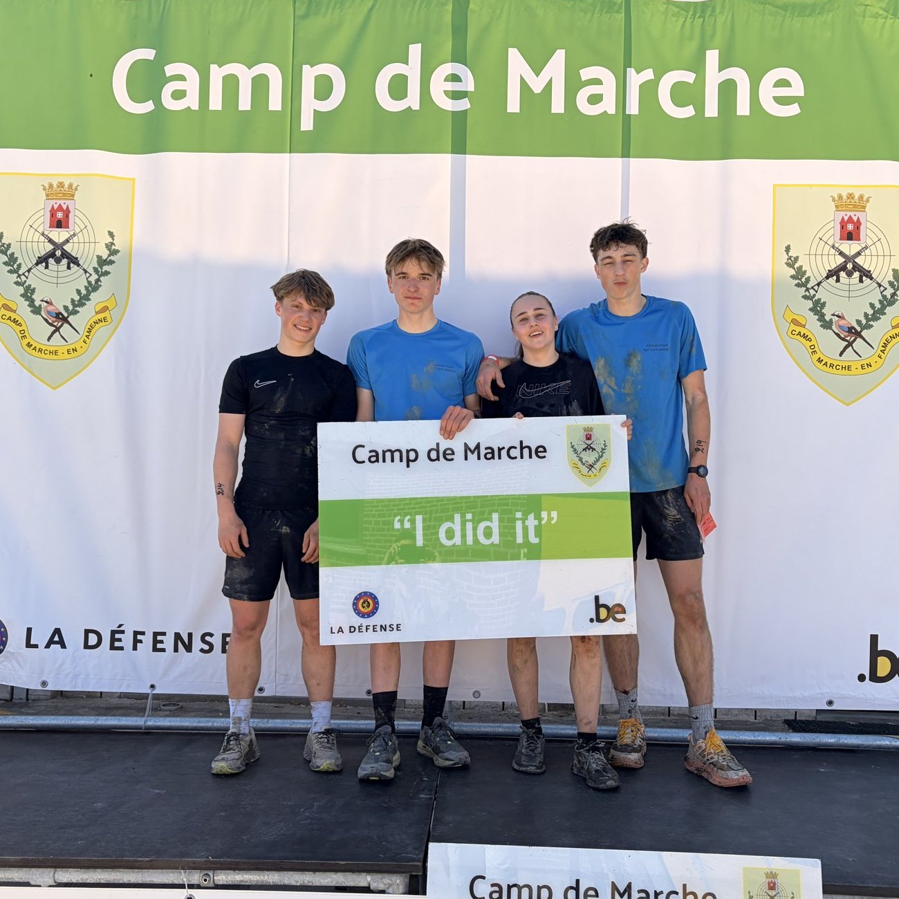 Une équipe d’élèves pleine de boue après le parcours Ent’Raid au Camp de Marche