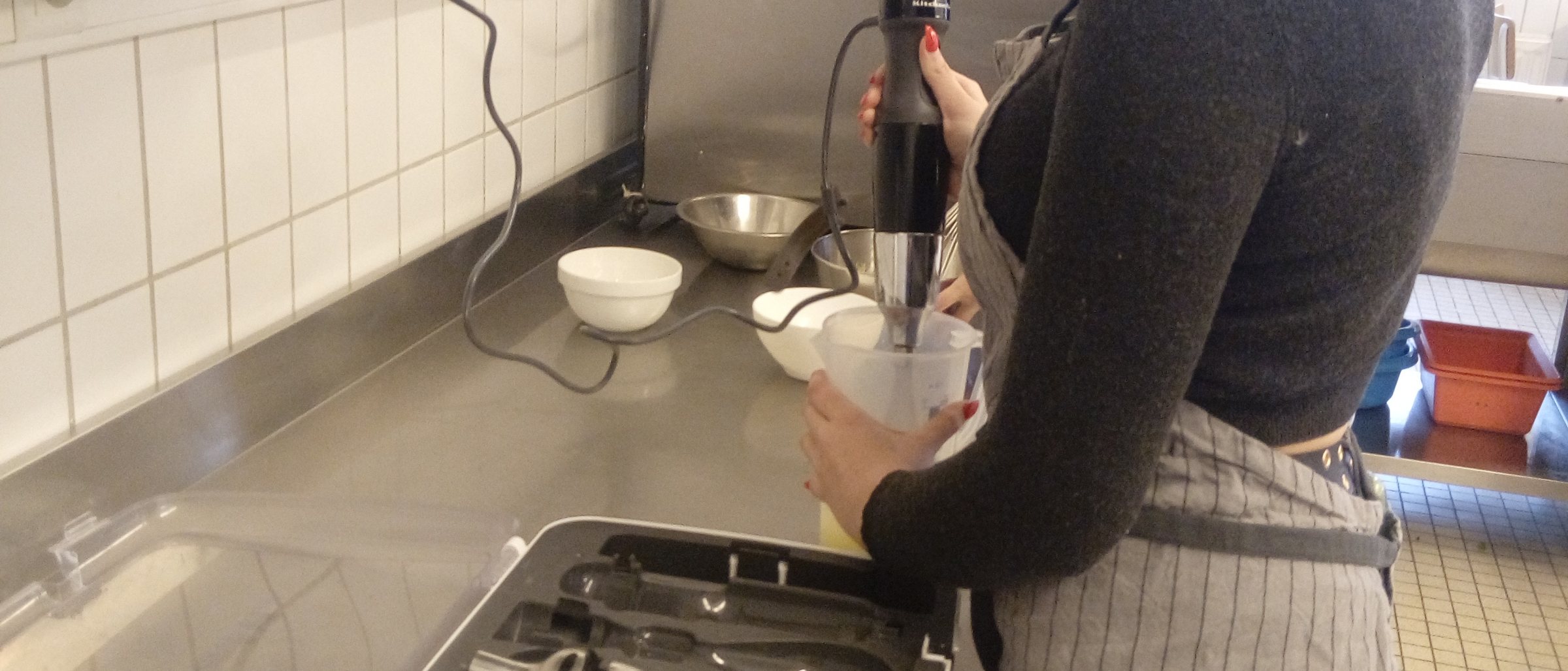 Élève en tablier mixant une préparation au laboratoire alimentaire