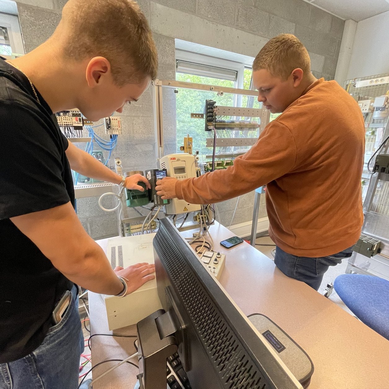 Deux élèves règlent un variateur de vitesse lors d’une formation à Technifutur