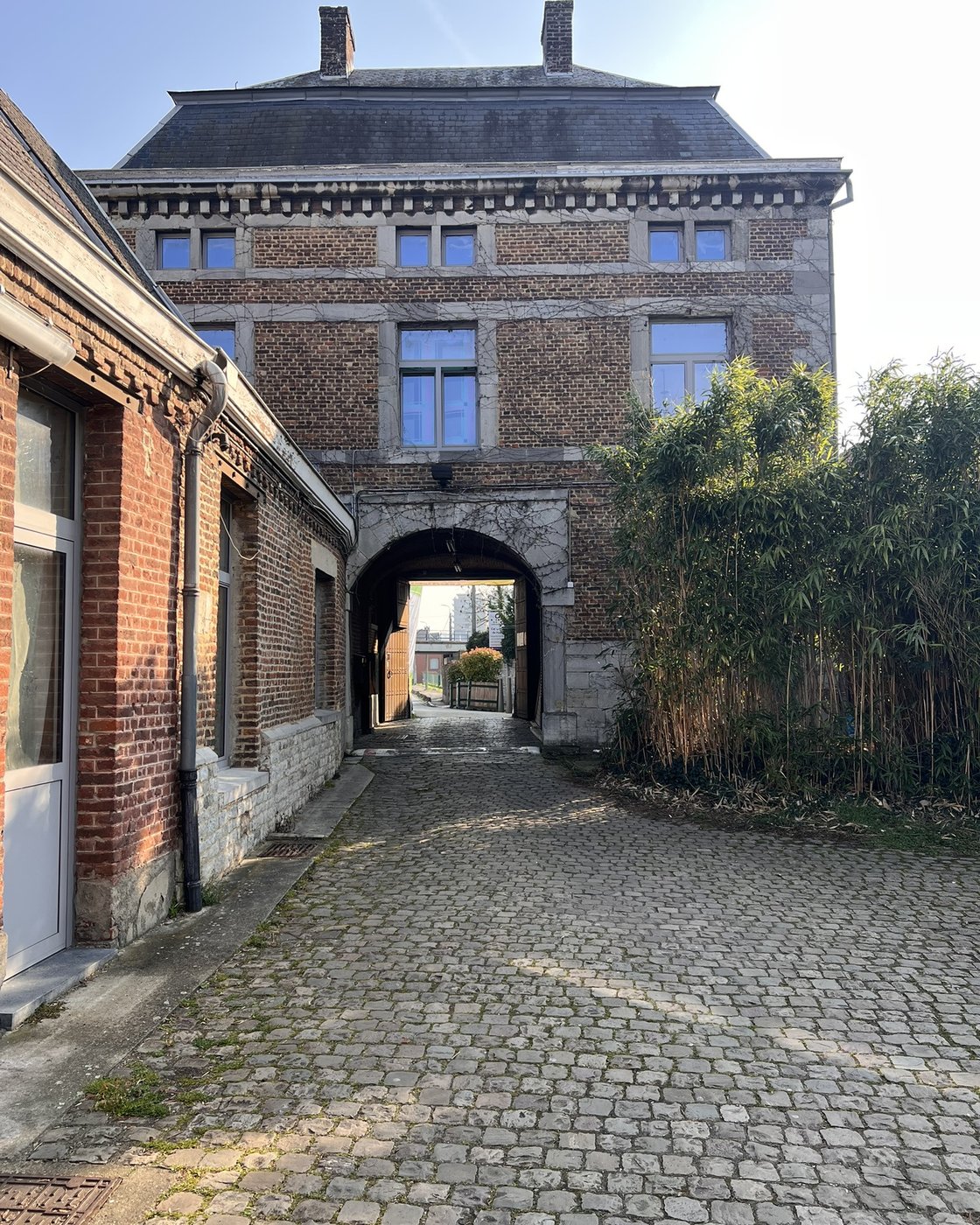 Porche voûté et ruelle pavée du campus de Huy