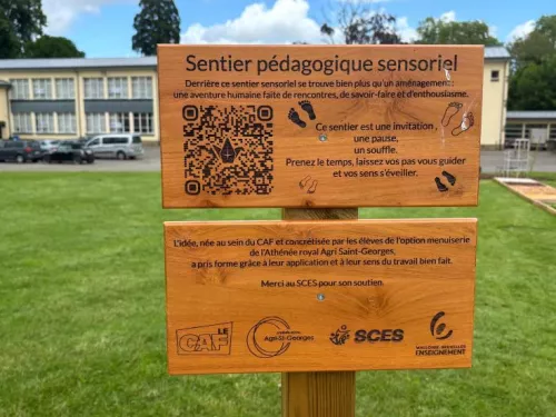 Le panneau en bois « Sentier pédagogique sensoriel » installé à l’entrée du sentier